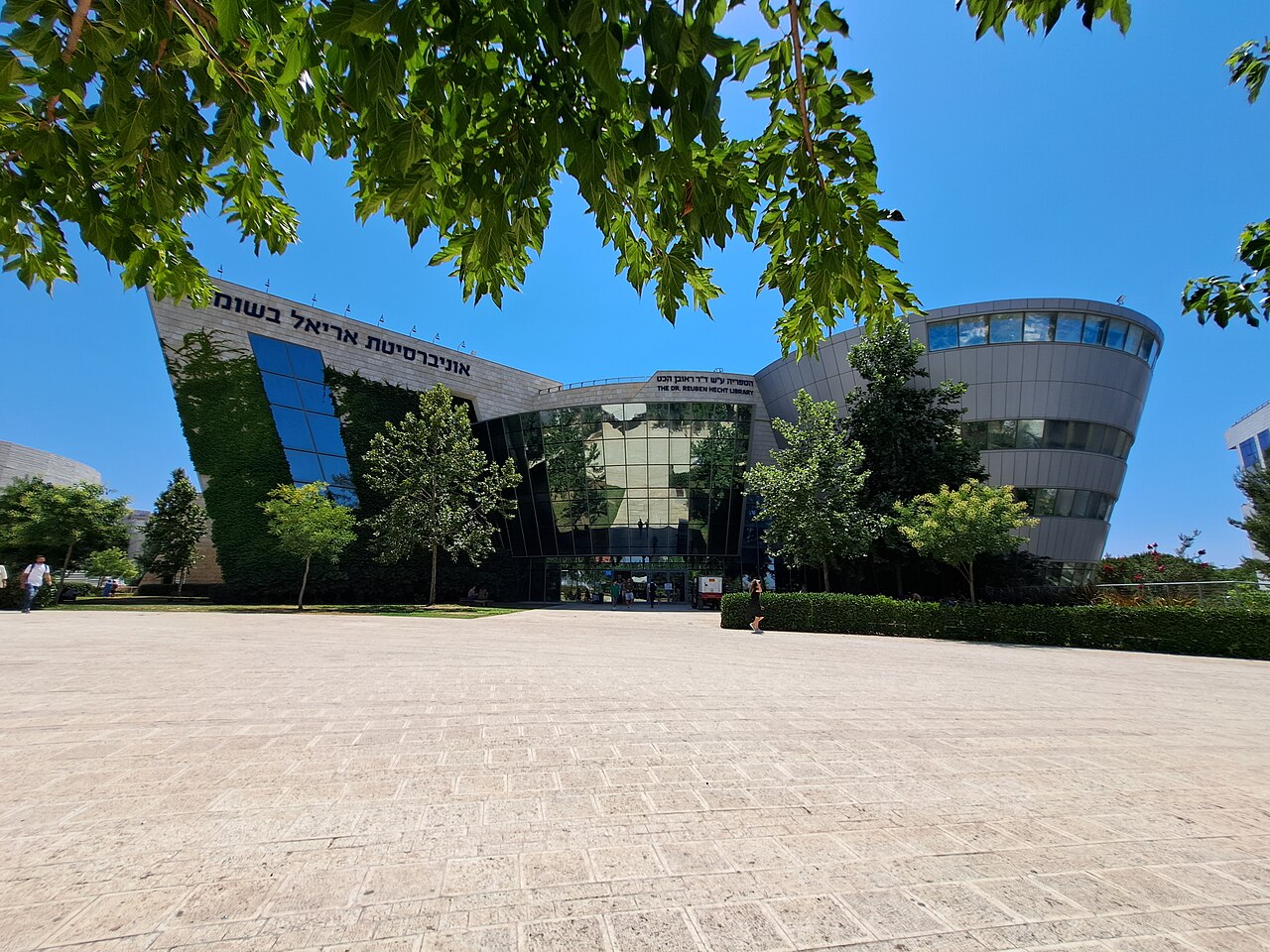 The Dr. Reuben Hecht Library at Ariel University, framed by leafy trees.